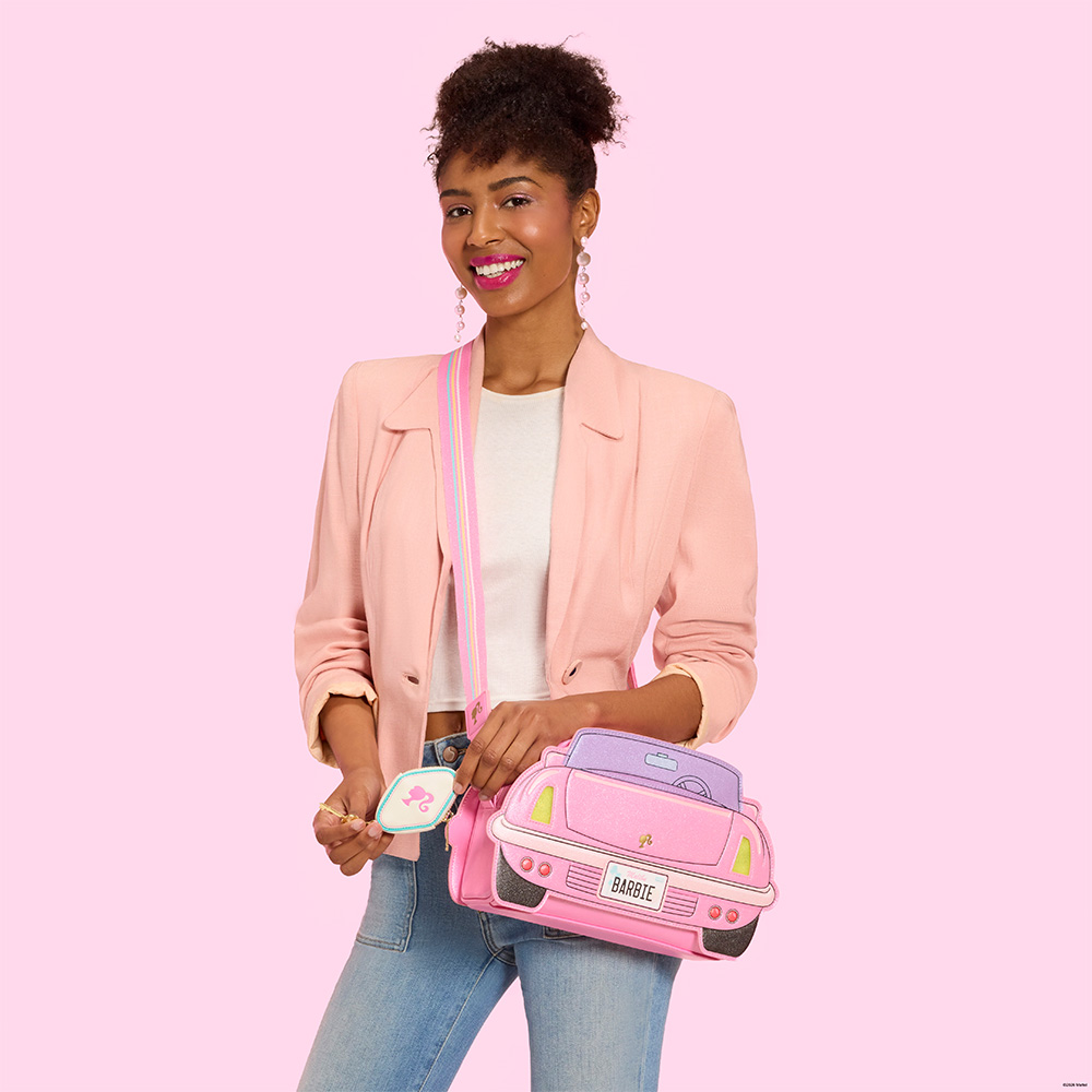 Pink background with model showcasing Loungefly Barbie bag