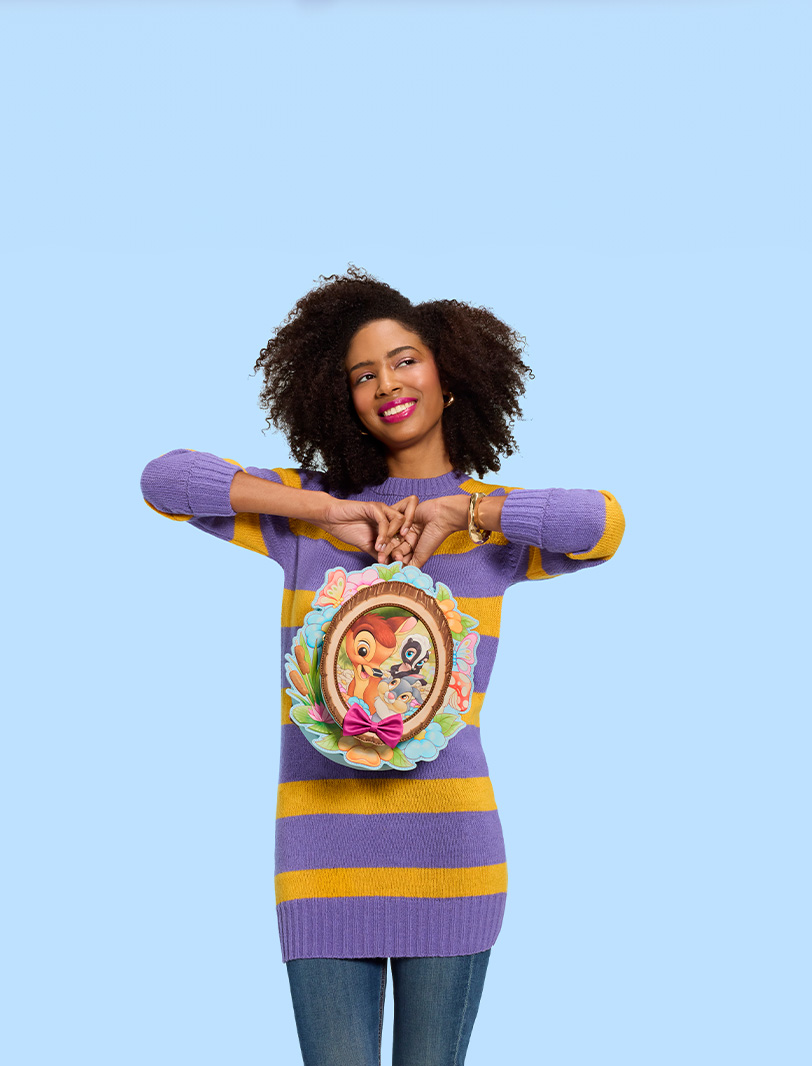 Blue background featuring model holding Loungefly Bambi cameo backpack