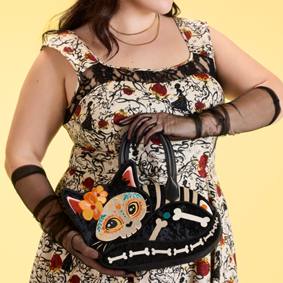 Model showcasing close up of cat shaped Dia Los Muertos bag