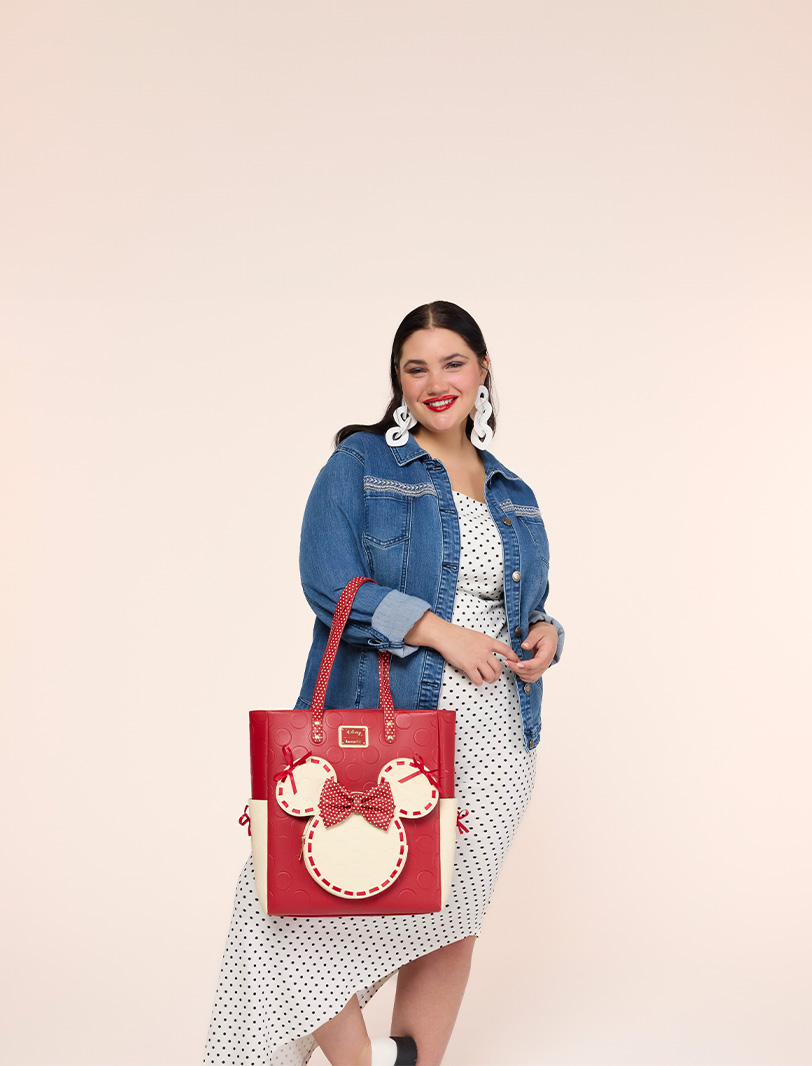 Neutral background featuring model with Loungefly Disney Minnie Rocks the Dots tote