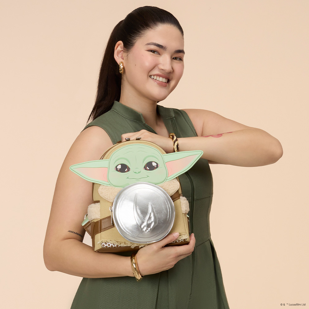 Tan background with model showcasing Loungefly Star Wars Mandalorian and Grogu mini backpack