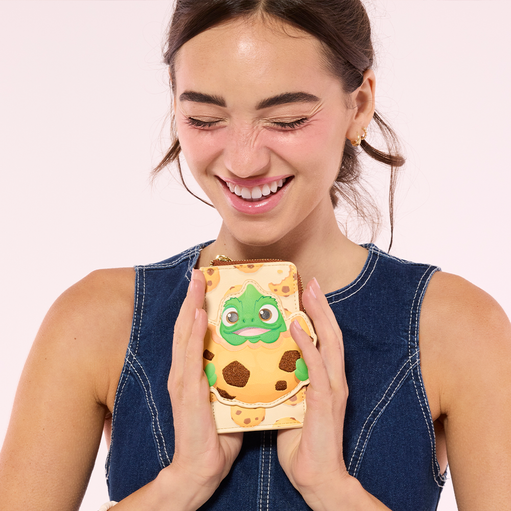 Pink background with model holding Loungefly Disney Tangled Pascal wallet