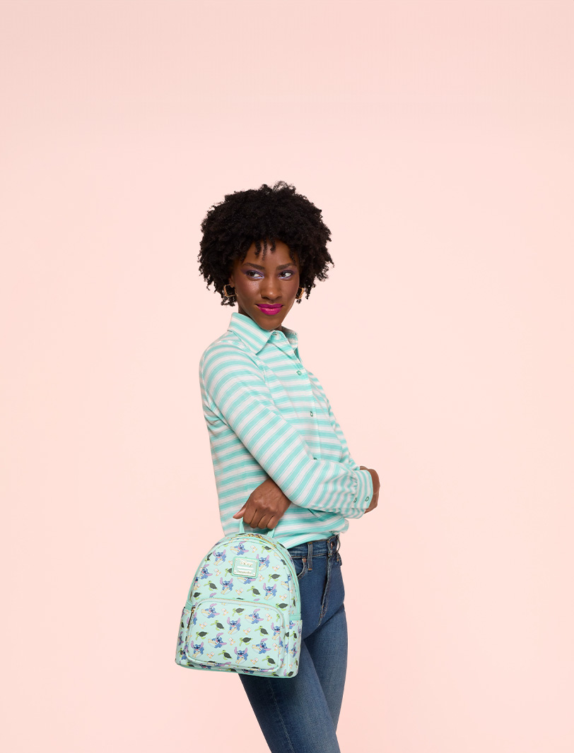 Pink background with model showcasing Loungefly Disney Lilo & Stitch collection