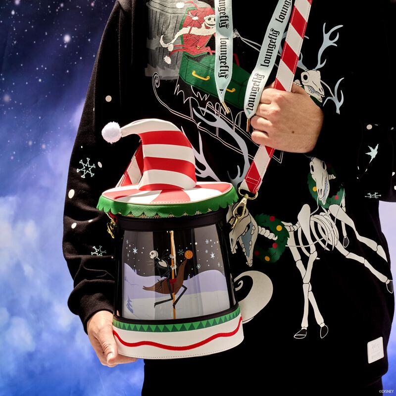 Man holding the Loungefly Nightmare Before Christmas Candy Cane Carousel Spinning Figural Crossbody Bag featuring Jack, Sally, and Zero riding an holiday-themed carousel.