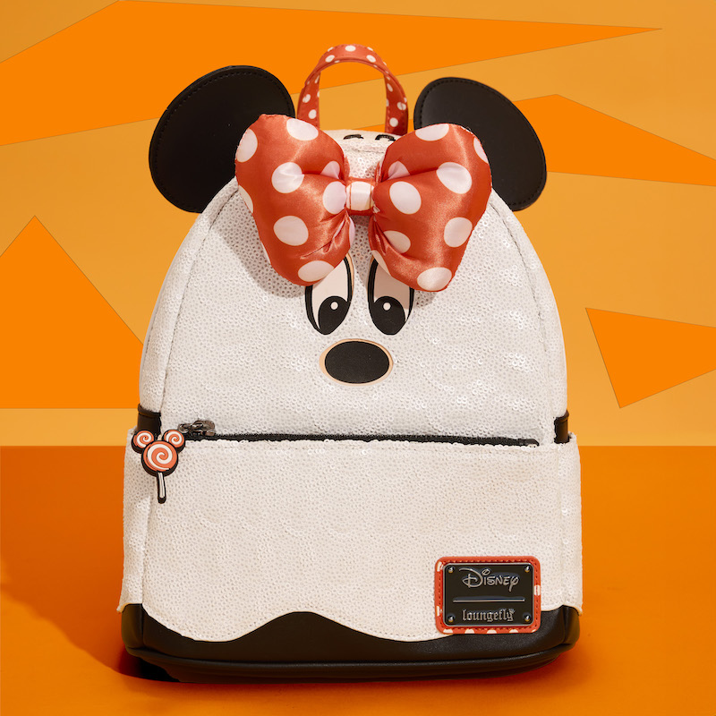 Loungefly mini backpack covered in white sequins and looks like Minnie Mouse as a ghost. It sits against an orange background.