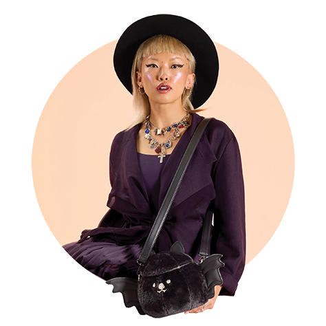 Circle-cropped photo with Tan background and model showcasing Loungefly Branded Halloween Bat Cosplay Crossbody Bag