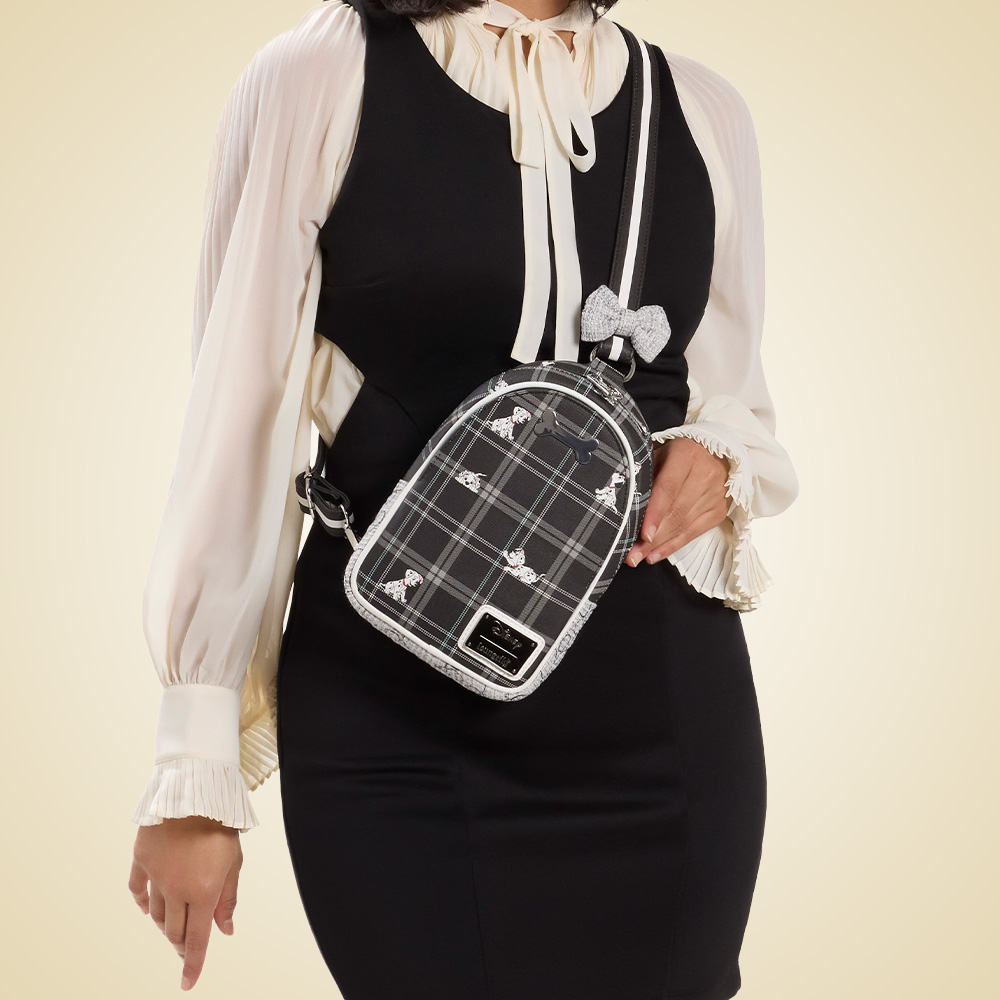 Olive Green background with model showcasing Loungefly Disney 101 Dalmatians Sling Bag