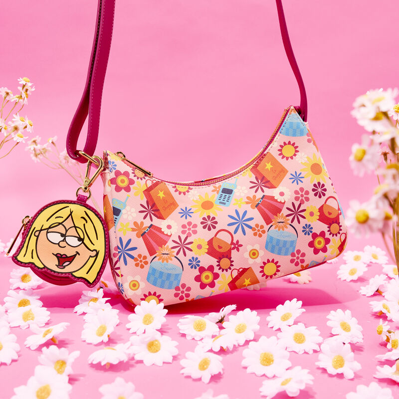 Pink Loungefly crossbody featuring Y2K symbols of cell phones, shopping bags, and flowers on it. Attached is a coin purse with an appliqué of the animated version of Lizzie McGuire. The bag sits against a pink background surrounded by daisies.