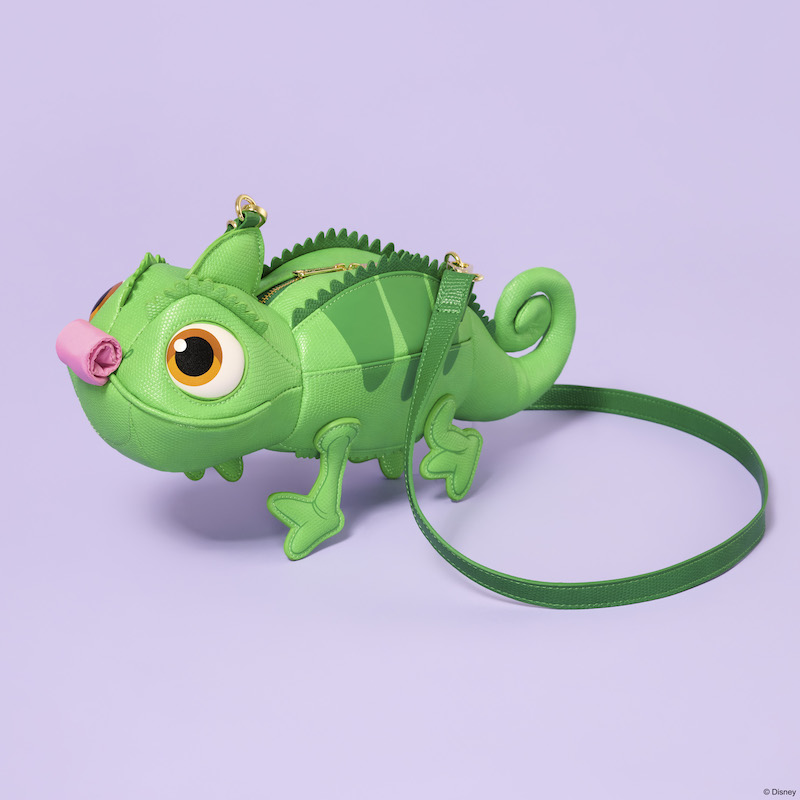 Figural crossbody in the shape of Disney's Pascal from Tangled with a rolled-up tongue sitting on a purple background.