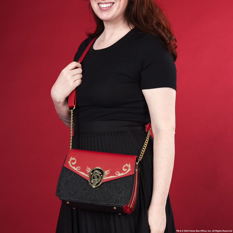 Woman wearing the House of the Dragon crossbody bag against a red background 
