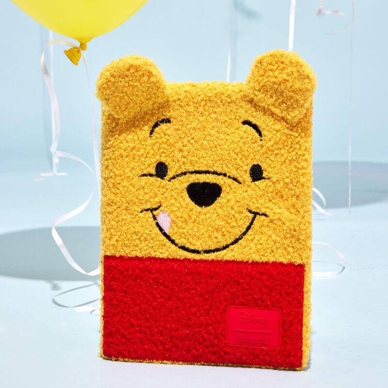 Winnie the Pooh plush journal with 3D ears that stick out from the top, standing against a light blue background with a yellow balloon behind it