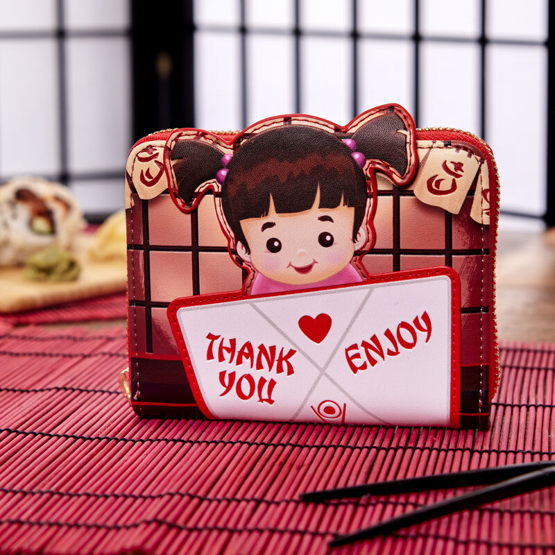 Image of the Loungefly Pixar Monsters, Inc. Harryhausen's Takeout Boo Wallet on a placemat on a table with sushi in the background