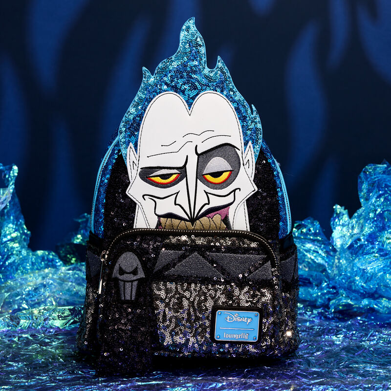 Sequin Loungefly mini backpack featuring Hades from Hercules in appliqué and sequin detail sitting against a dark background with fake blue flames around it. 