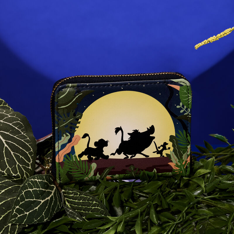 Lion King 30th Anniversary Hakuna Matata Silhouette Zip Around Wallet sitting amongst green vegetation against a blue background. 