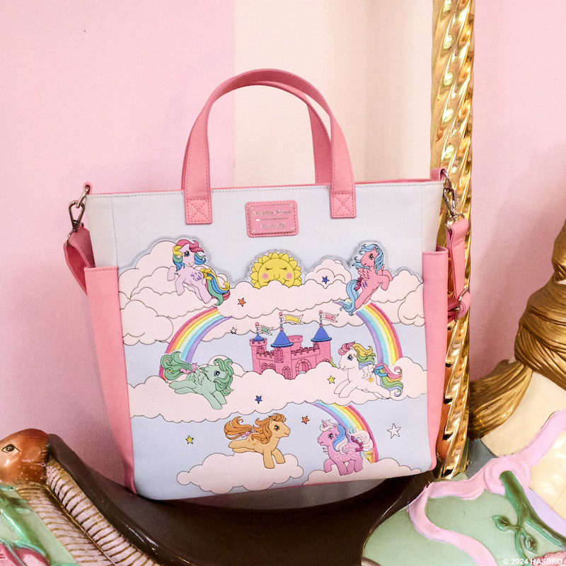 My Little Pony convertible backpack and tote bag sitting on the back of a carousel horse, featuring an image of various My Little Pony characters prancing across clouds and rainbows. 