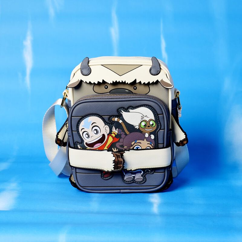 Image of our Avatar: The Last Airbender Appa CROSSBUDDIES bag against a blue background with the attachable pouch showing the side with Aang, Katara, and Momo
