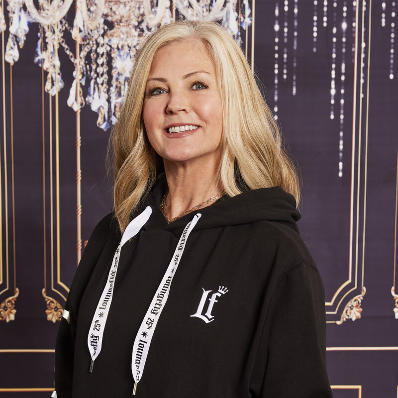 Image of woman wearing the Loungefly 25th Anniversary Hoodie against a sparkly background