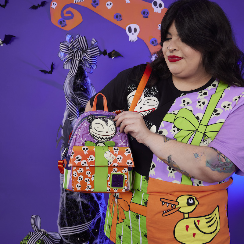 Woman wearing the Nightmare Before Christmas Toys Unisex Tee and holding the Scary Teddy Mini Backpack 