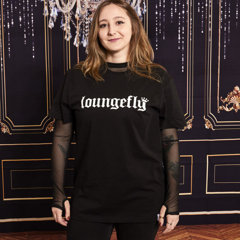Woman wearing the Loungefly 25th anniversary unisex tee that says "Loungefly" on the front 