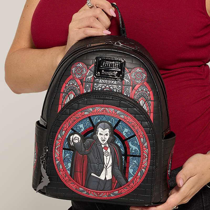 Gray background with model holding Loungefly Universal Monsters Dracula mini backpack