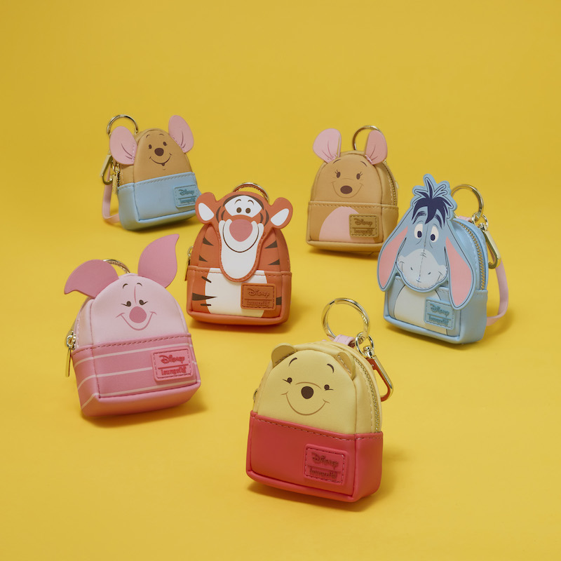 Loungefly Winnie the Pooh Mini Backpack Keychain Charms displayed together on a yellow background, featuring Winnie the Pooh, Piglet, Tigger, Eeyore, Roo, and Kanga. 