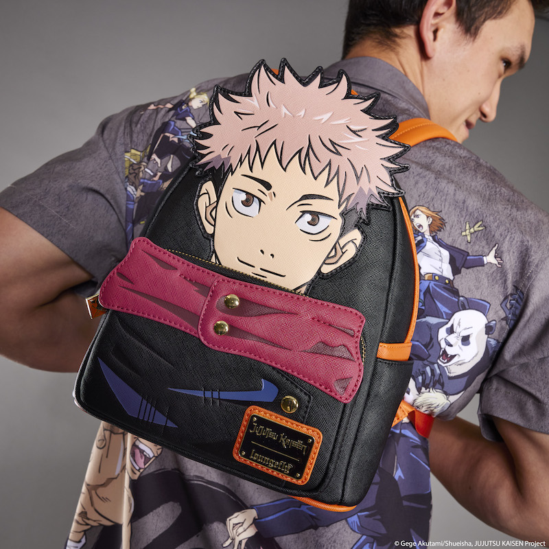 Man wearing the Loungefly JUJUTSU Kaisen Sorcerer Battle Camp Shirt facing away from camera and showing off the Loungefly JUJUTSU KAISEN Yuji Itadori Cosplay mini backpack, featuring Yuji as a large appliqu&eacute; on the front of the black bag. The front pockets include details of his outfit, including a red appliqu&eacute; collar. 