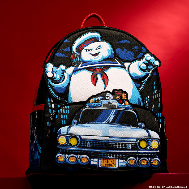 Loungefly Ghostbusters mini backpack featuring the Ecto-1 driving in front of the Stay Puft Marshmallow Man. The bag sits against a red background. 