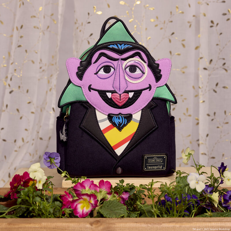 Loungefly Count Von Count mini backpack featuring the Count in applique and embroidered detail. The bag sits on a windowsill with a flowerbed and translucent curtains behind it. 