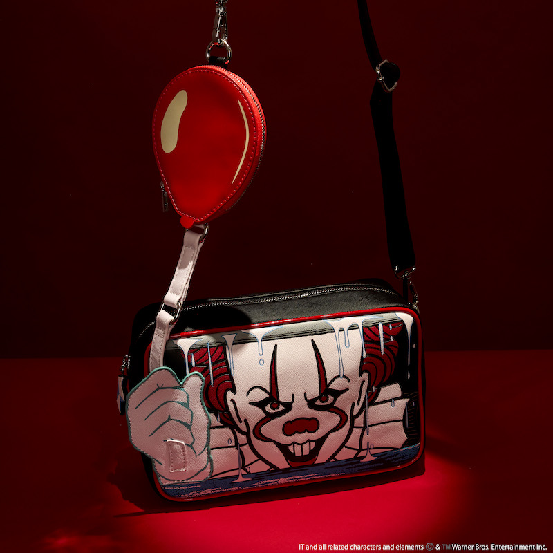 Loungefly It Pennywise Balloon Glow Crossbody Bag featuring Pennywise holding a balloon looking out from a storm drain against a dark red background.