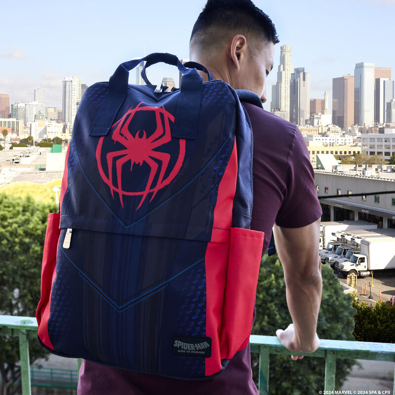 Man standing on a fire escape looking out onto the city wearing the full-size Spider-Verse Miles Morales Nylon Backpack