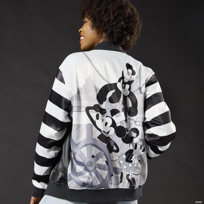 Woman facing away from camera wearing the Loungefly Disney Steamboat Willie Bomber Jacket, featuring characters from the film on the back of the jacket on the steamboat.