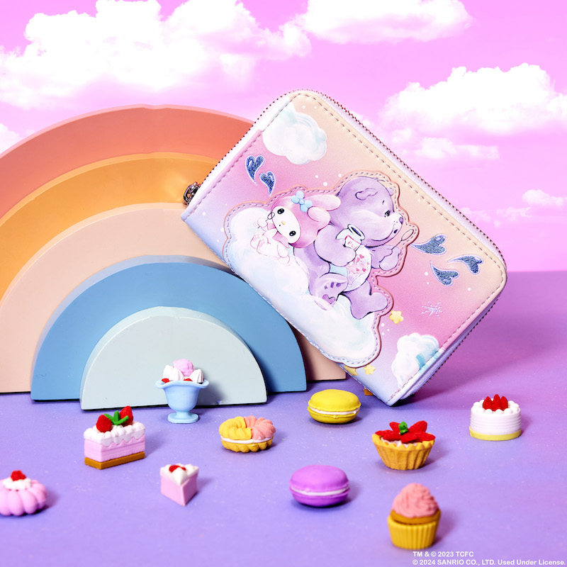 Image of the Care Bears x Sanrio collab zip around wallet against a pink background with clouds with mini desserts in front of it 