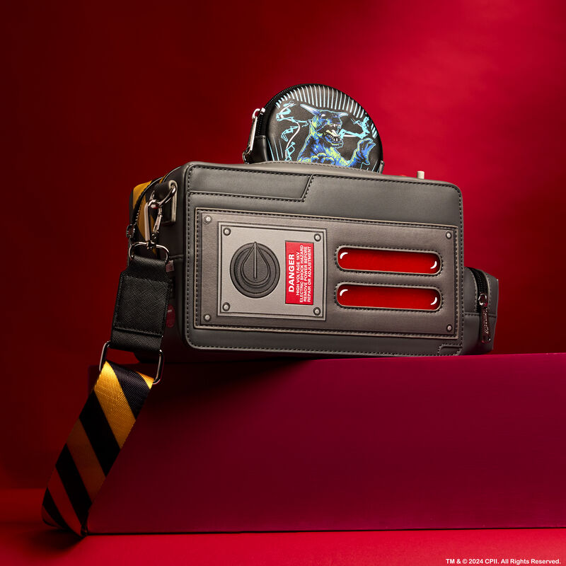 Figural Loungefly bag in the shape of a ghost trap from Ghostbusters. It sits against a red background on a red platform.