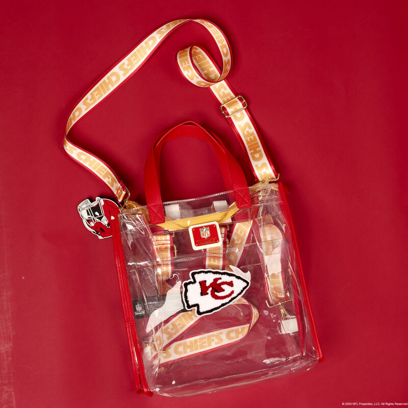 Clear Loungefly convertible tote and mini backpack featuring the Kansas City Chiefs logo in the center. The bag sits against a red background. 