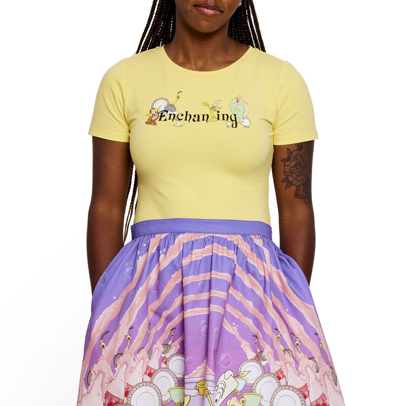 woman wearing the yellow Ariana top that says "Enchanting" on the front with characters from Beauty and the Beast surrounding the letters