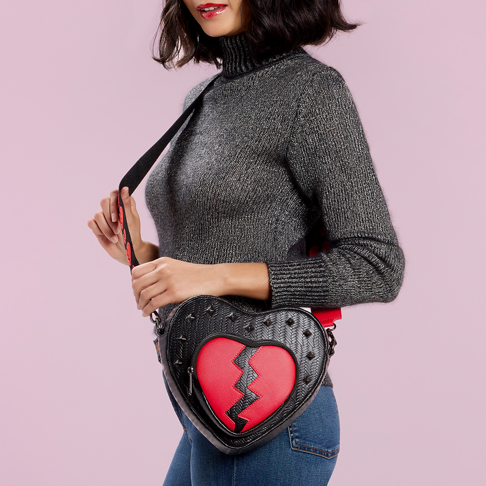 Purple background with model showcasing Loungefly Branded Broken Heart Crossbody bag 