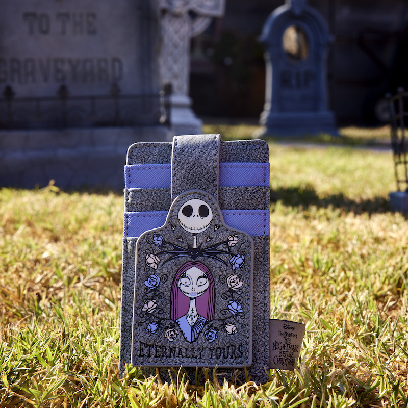 Image of our Jack and Sally Tombstone Card Holder sitting in a graveyard with other tombstones in the background 