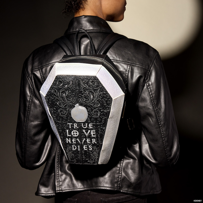 Woman facing away from camera wearing a black leather jacket and wearing the Loungefly Coffin-Shaped Nightmare Before Christmas Mini Backpack, which says "True Love Never Dies" on it 