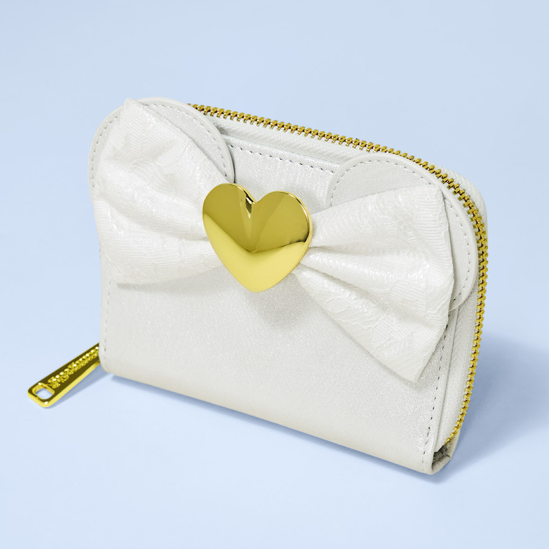 White iridescent lace Minnie Mouse wallet from Loungefly, featuring 3D applique ears and a lace bow with a golden heart in the center. The wallet sits against a light blue background. 