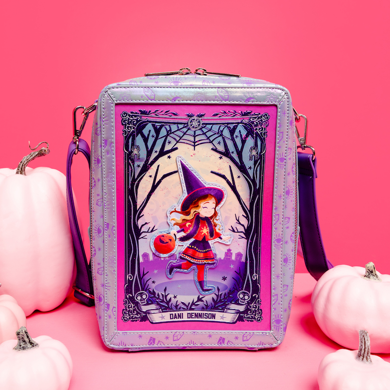 Rectangular Loungefly crossbody bag that looks like a tarot card with Dani Dennison from Hocus Pocus on the front skipping through the woods. The bag sits against a pink background with light pink pumpkins. 