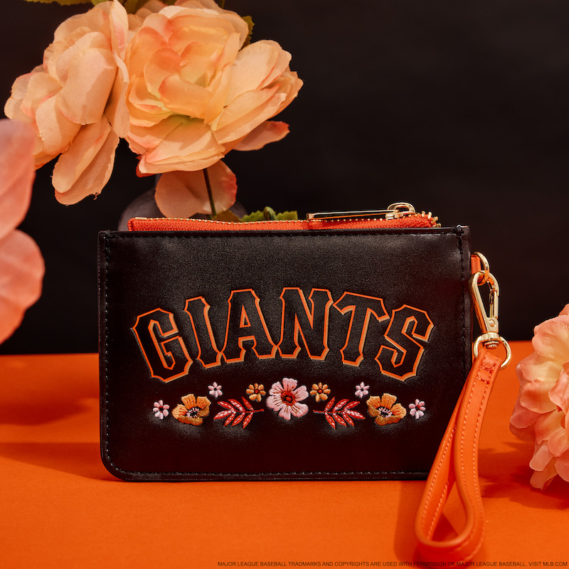 Black and orange floral San Francisco Giants wristlet clutch against a black and orange background surrounded by orange flowers