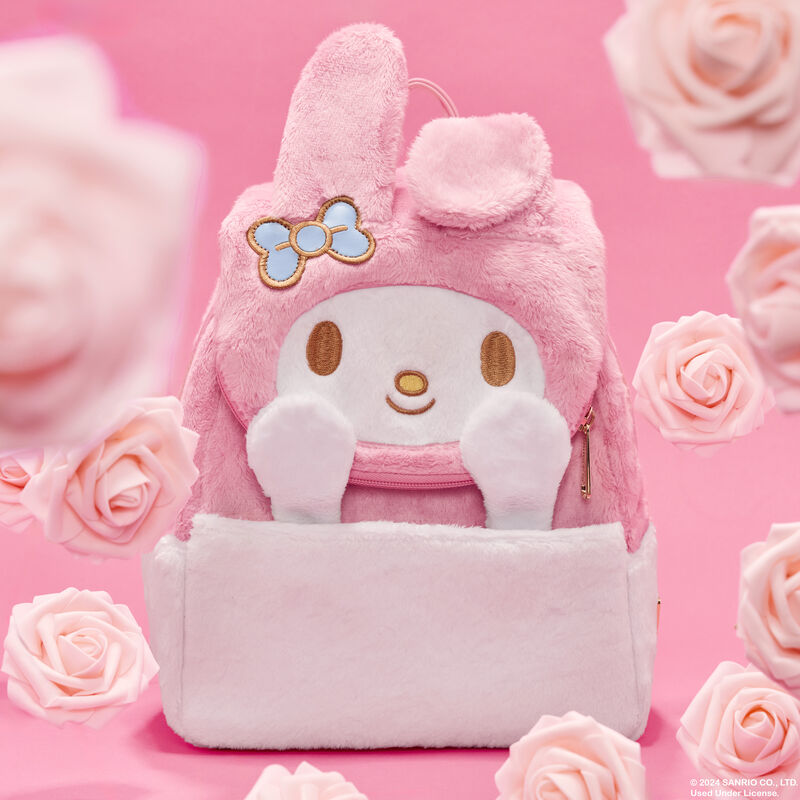 Plush Loungefly backpack featuring My Melody with her hands sticking up. The Loungefly Sanrio bag sits against a pink background surrounded by roses.