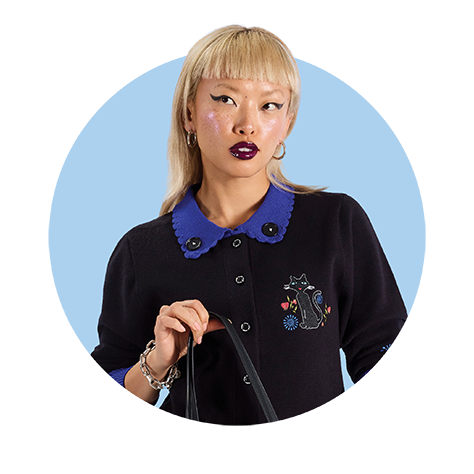 Circle-cropped photo with Blue background and model wearing Loungefly Laika Coraline cardigan