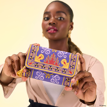 Yellow background with model showcasing Loungefly Disney Aladdin Magic Carpet exclusive wallet