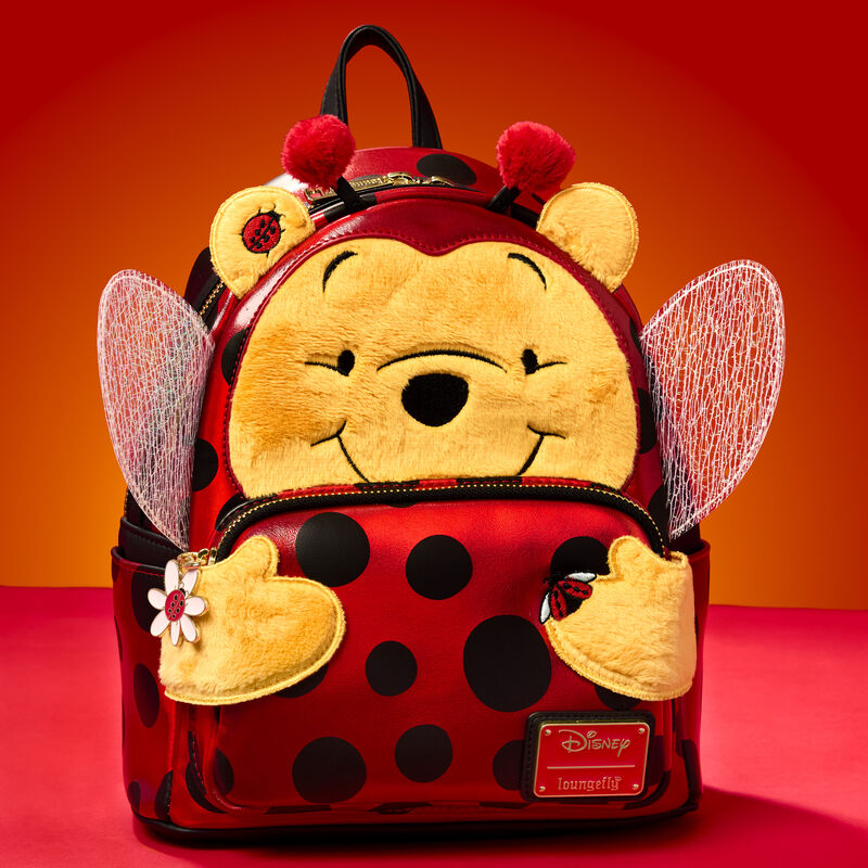 Loungefly mini backpack featuring Winnie the Pooh dressed as a ladybug. The bag sits against a red background.