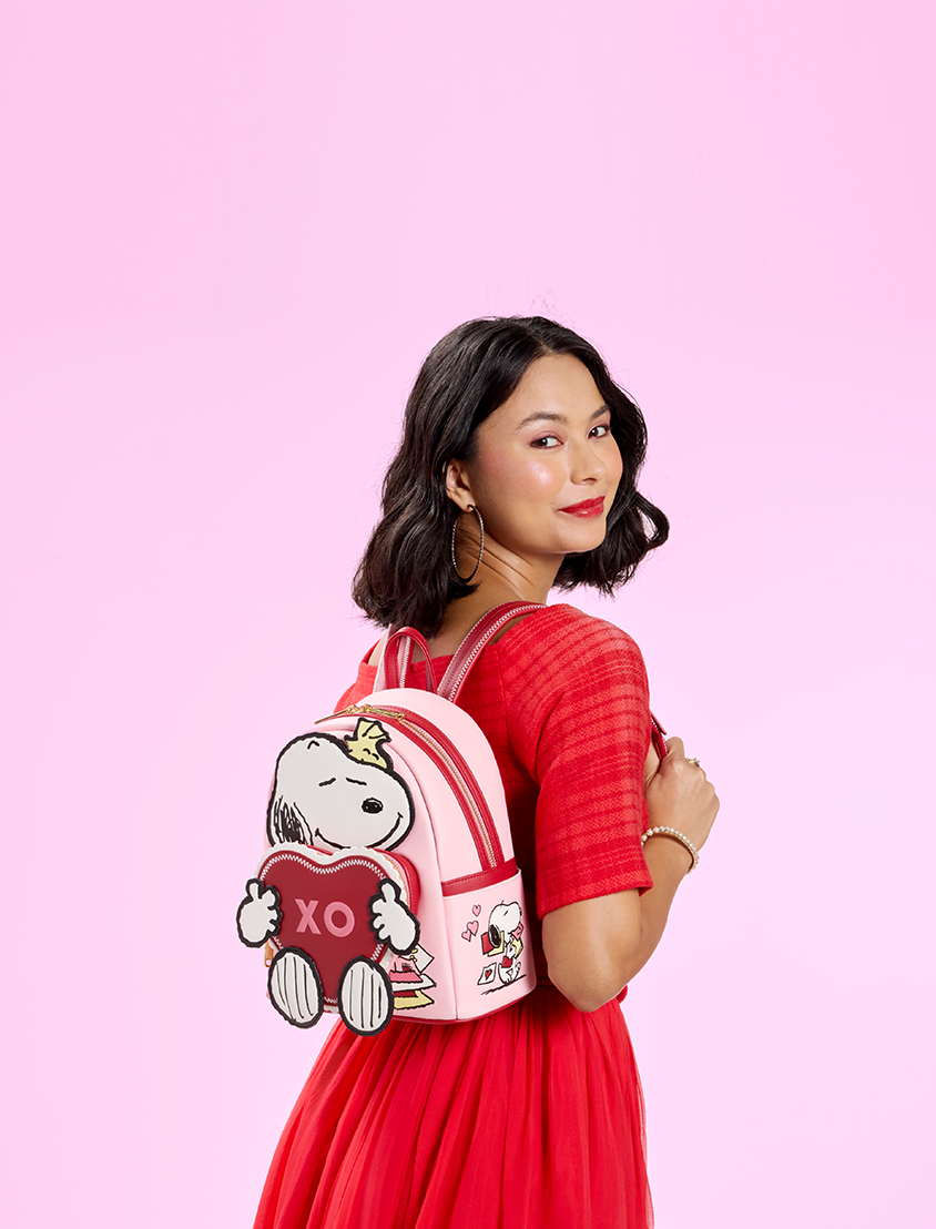 Pink background with model showcasing Loungefly Peanuts Valentine's Snoopy Mini Backpack