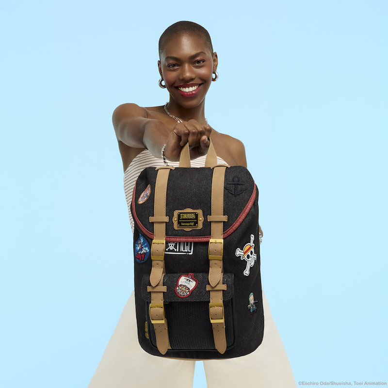 Woman smiling and holding the Loungefly SDCC Limited Edition One Piece Backpack toward camera.