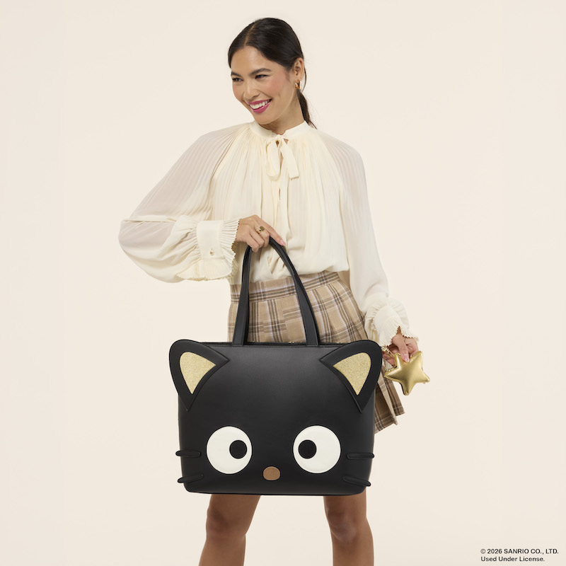 Woman wearing a white blouse and plaid skirt, holding the Loungefly Chococat tote bag.