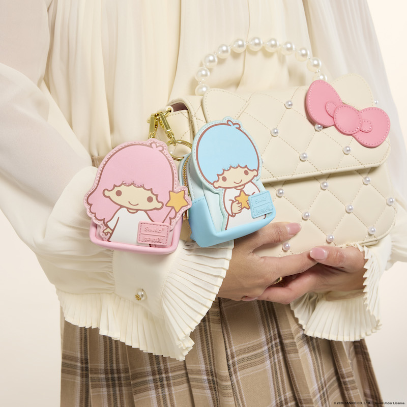 Close up shot of two of the Loungefly Sanrio Characters Mystery mini backpack keychain charms, Kiki and Lala, attached to a Hello Kitty crossbody bag.