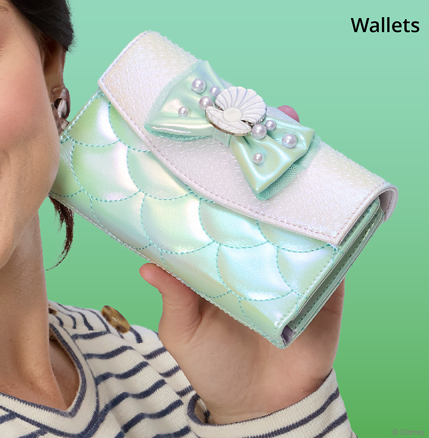 Green background with model hand holding Loungefly Disney Little Mermaid wallet